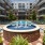 a fountain in a courtyard with buildings in the background