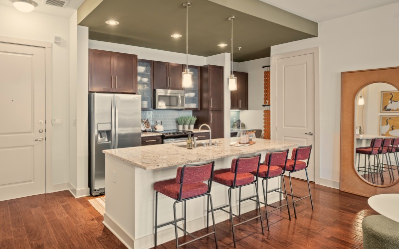 kitchen iwth brown cabinets and island with bar stools