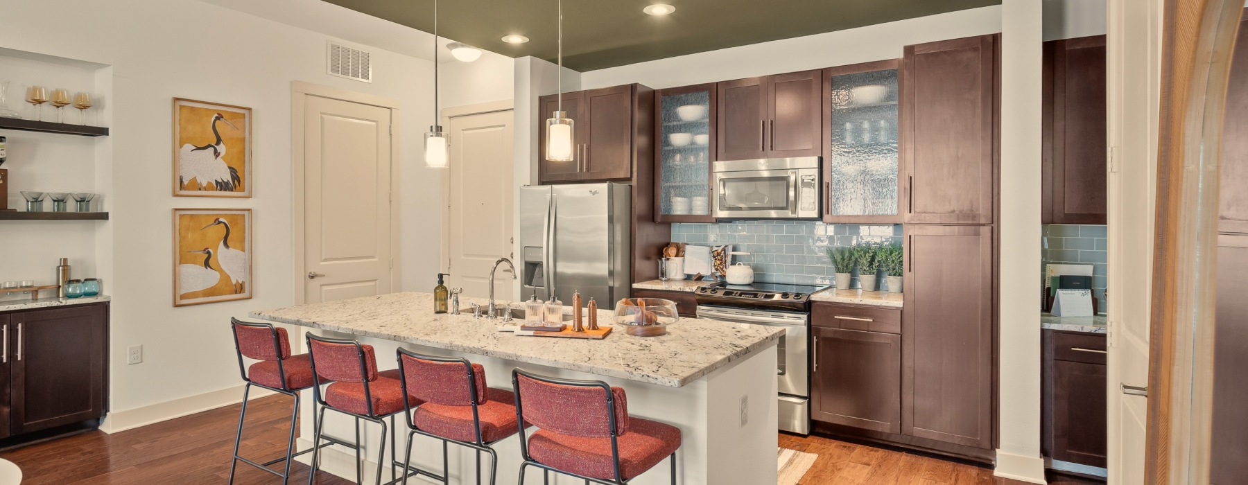 Modern kitchen with maple cabinetry and hardwood floors at Virage on Memorial luxury apartments in Houston, TX.