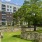 a building with a stone wall and trees in front of it